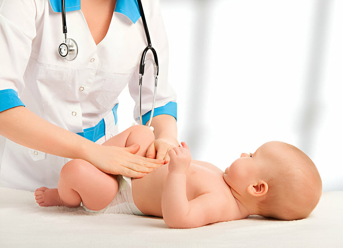 una mujer médico revisando la panza estómago de un bebé pequeño