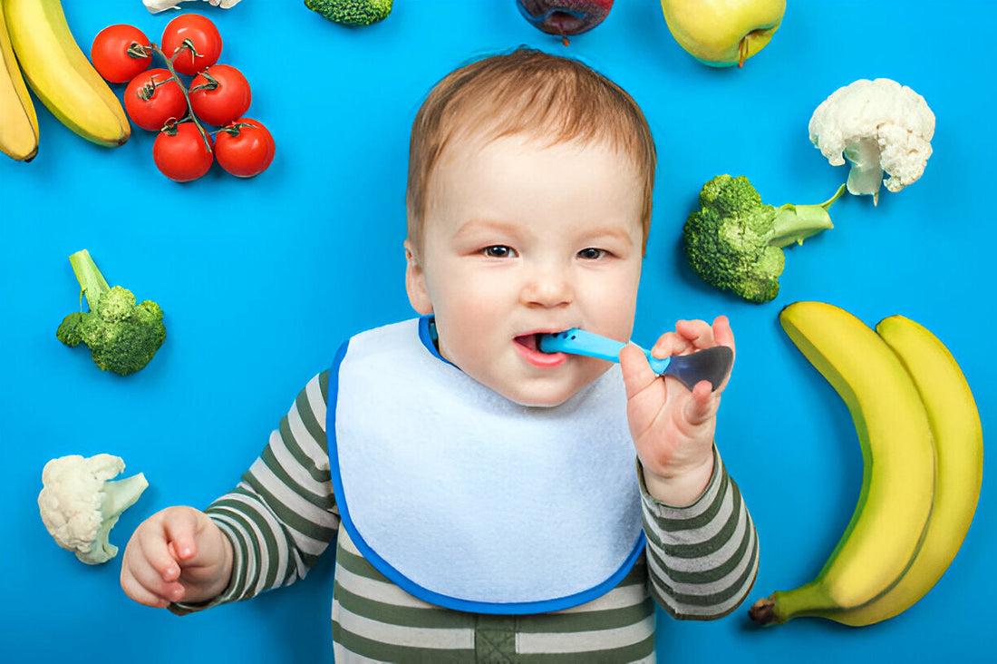 Bebé acostado sobre fondo azul y con frutas a su alrededor. Alimentación complementaria