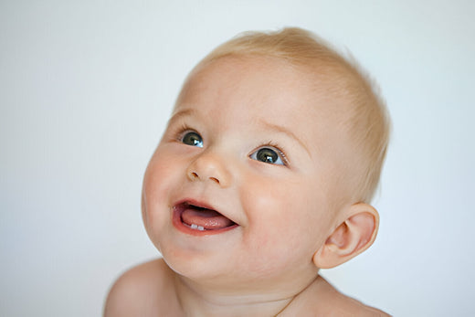Bebé rubio con dos dientes abajo. El niño está comenzando su dentición 