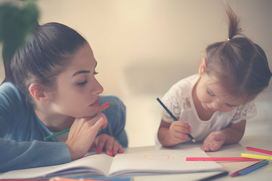 Mamá coloreando con su bebé niña
